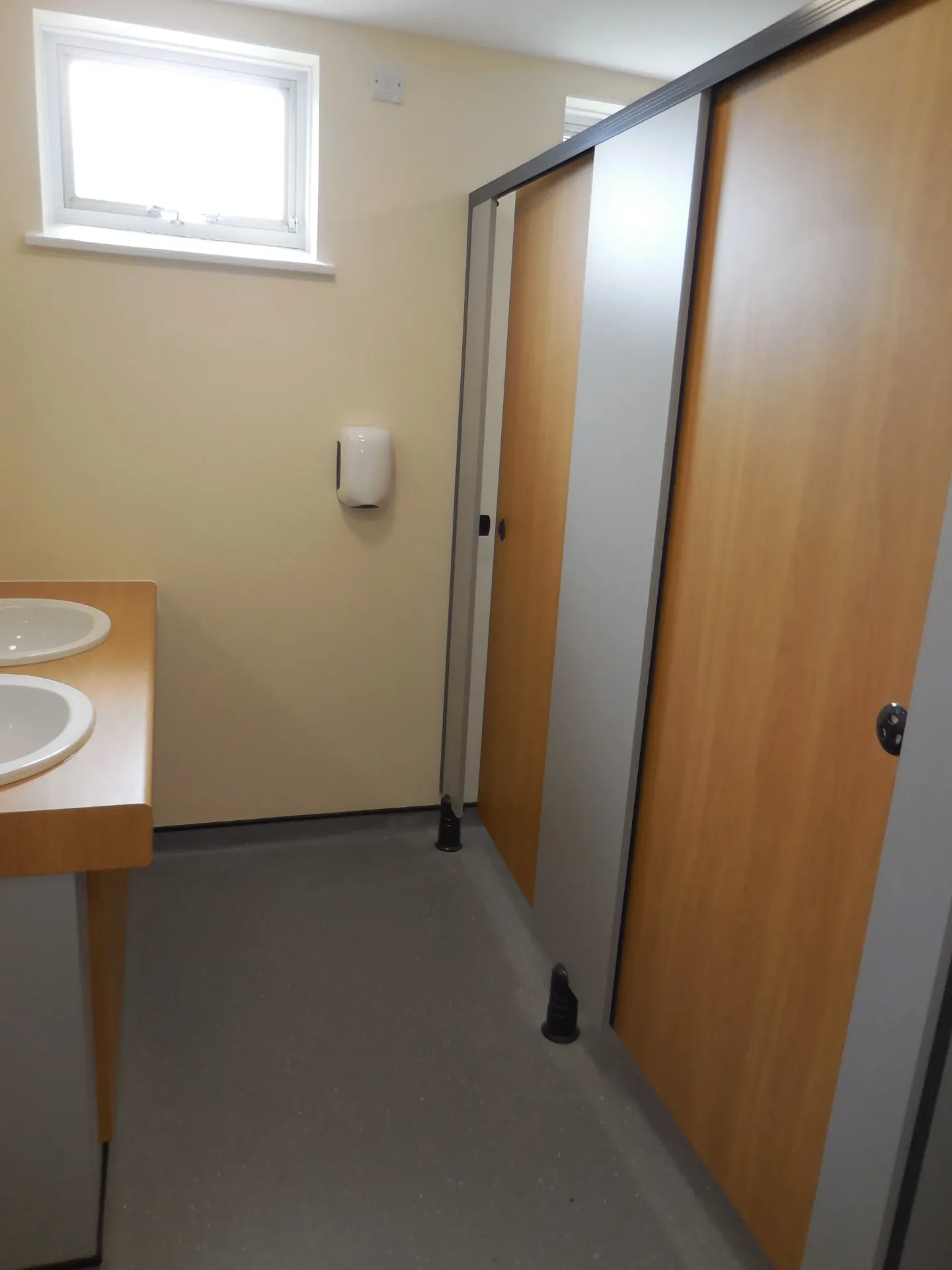 Shared washroom with twin basins and cubicles